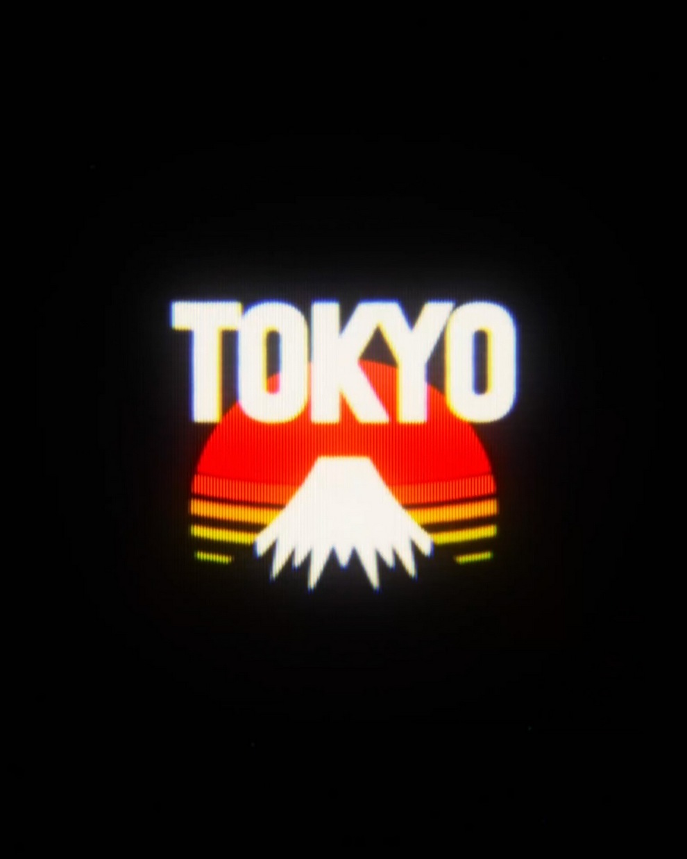 Logo displaying the word 'TOKYO' with a stylized representation of Mount Fuji and a sunburst motif in the background.