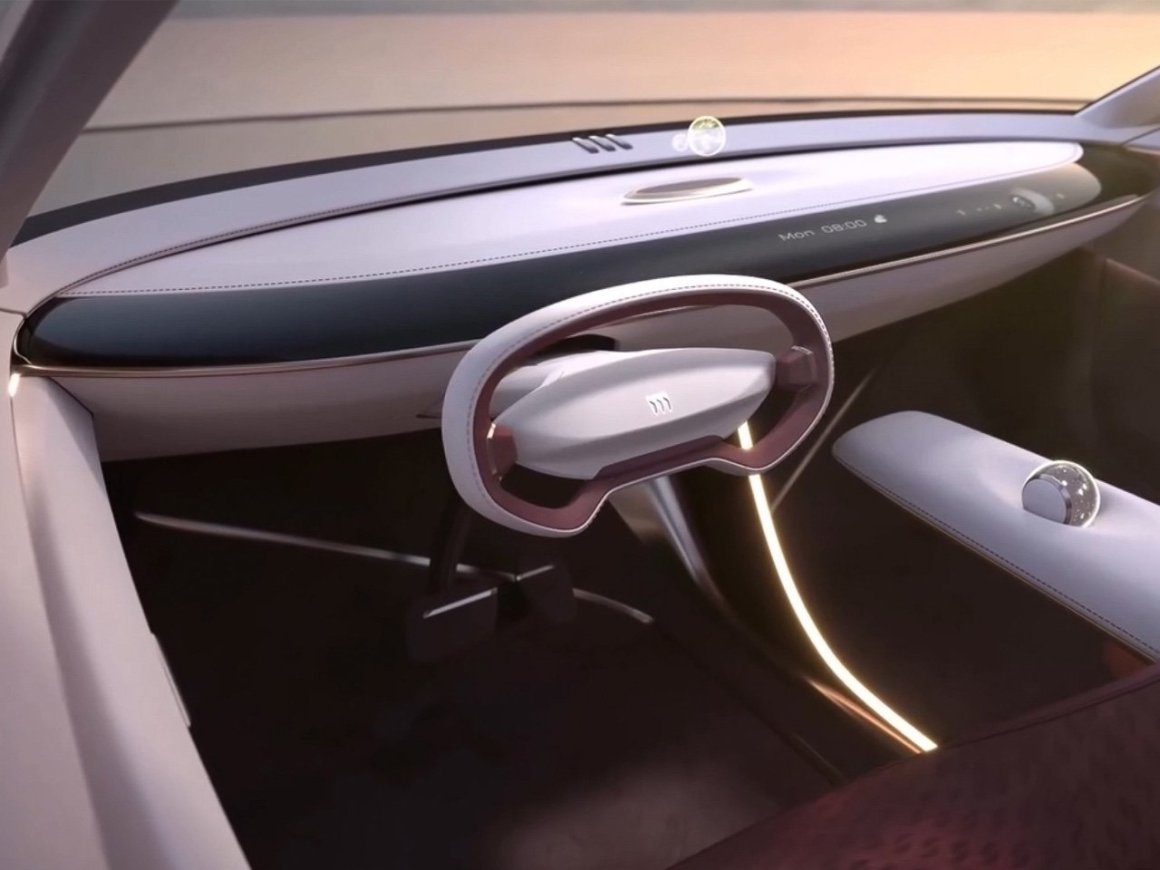 Interior view of the Buick Electra Orbit concept showcasing a modern dashboard with a unique, minimalist steering wheel and a futuristic interface design.