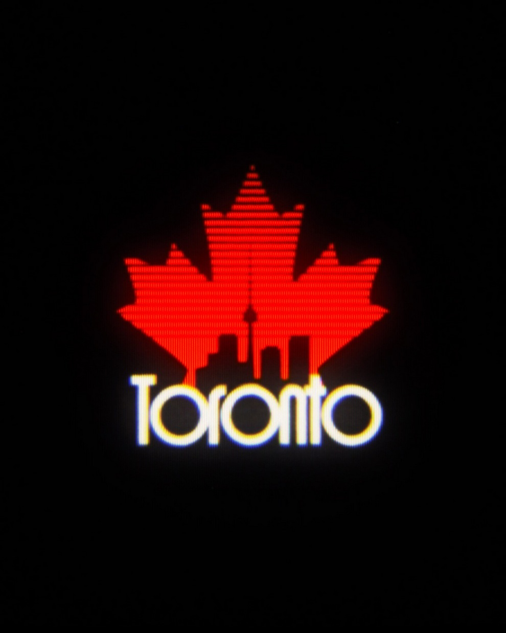 A stylized red maple leaf graphic combined with a silhouette of the Toronto skyline and the word 'Toronto' written underneath in white and yellow.