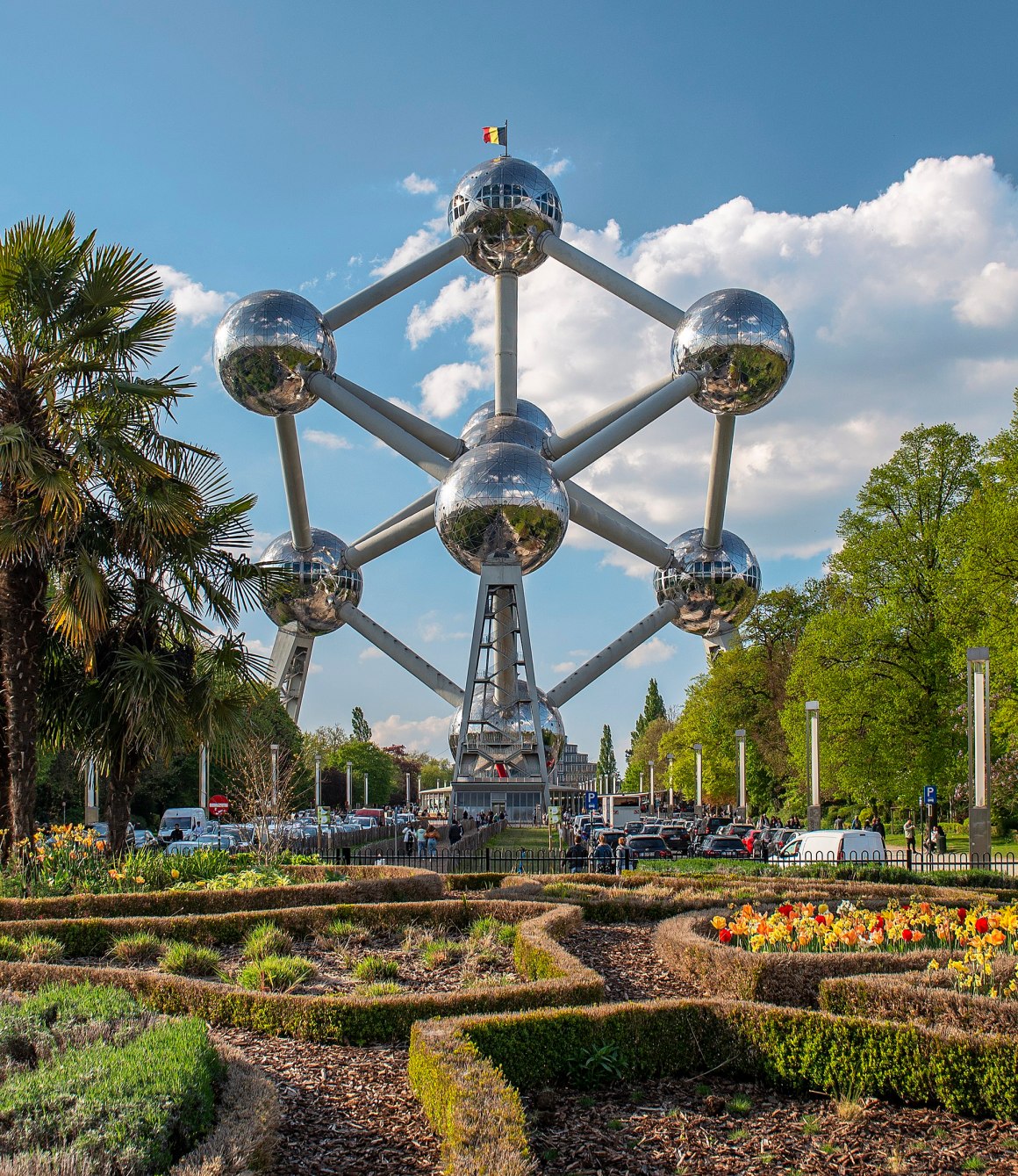 The Atomium in Brussels, featuring its iconic nine spherical structures connected by tubes, surrounded by landscaped gardens.