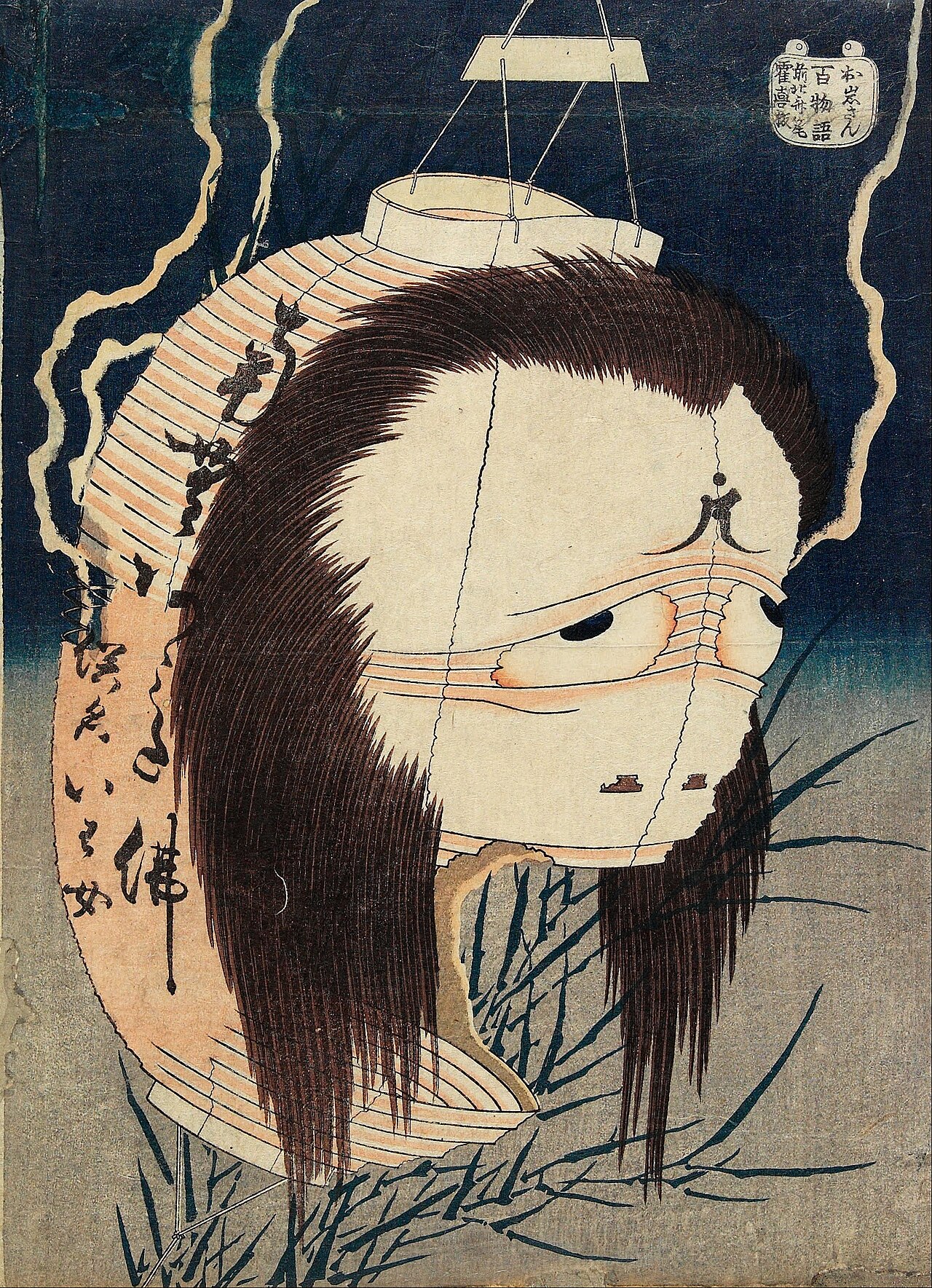 Hokusai woodblock print of the ghost Oiwa, her swollen pale face with one drooping eye formed from a torn paper lantern hanging from a frame, long black hair spilling down, against a dark blue sky